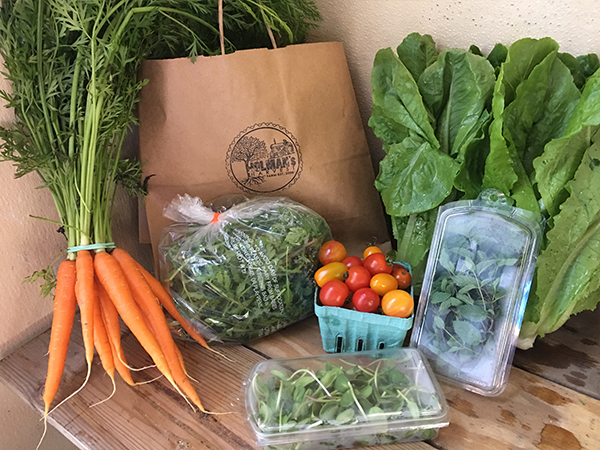 A bag of vegetables and a bag of carrots on a table.