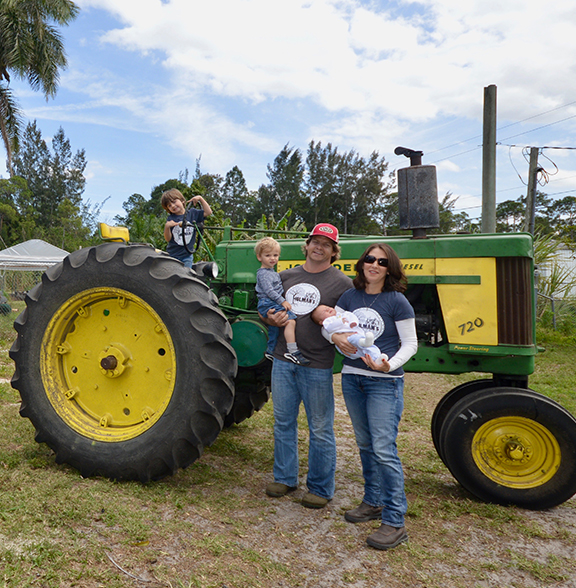 A family posing in front of a tractor.